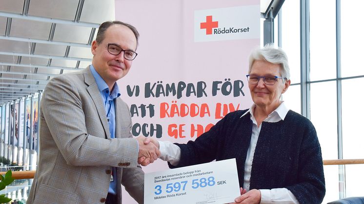 Swedavia’s chief executive, Jonas Abrahamsson, hands over a check for 3.6 million kronor to the president of the Swedish Red Cross, Margareta Wahlström. Photo: Frida Weberg