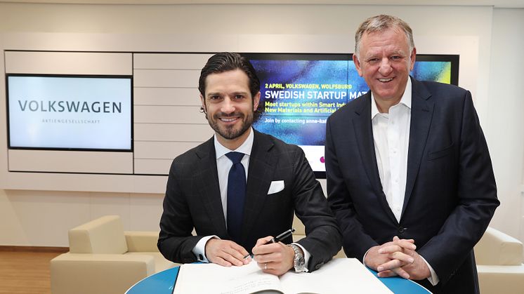 Prins Carl Philip skriver en hälsning i Volkswagens gästbok. Till höger: Andreas Renschler, VD för TRATON SE och styrelseledamot i Volkswagen AG.