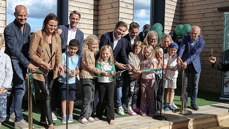 Hampus Magnusson klipper bandet tillsammans med barn från Nobla skolan och representanter från AcadeMedia, Bygg-göta och Next Step Group.