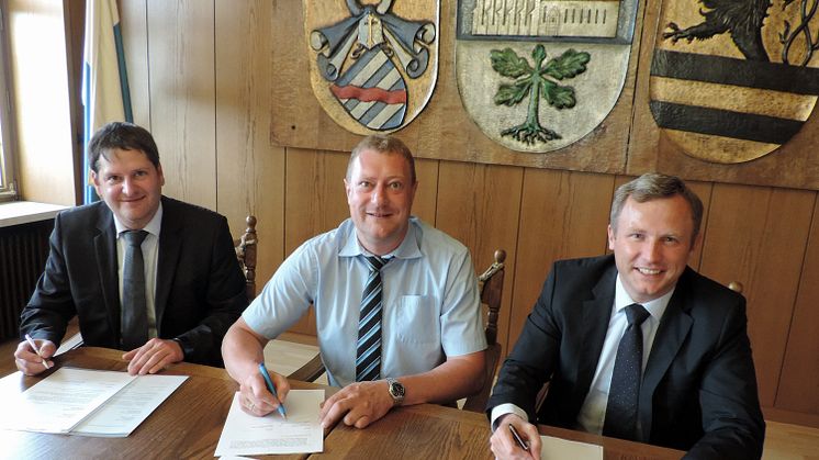 Erster Bürgermeister Michael Keilich unterzeichnet mit Bernd Göttlicher, Leiter Kommunen und Kooperationen Oberfranken (r.), und Kommunalbetreuer Christian Ziegler (l.) im Sonnefelder Rathaus den neuen Konzessionsvertrag.