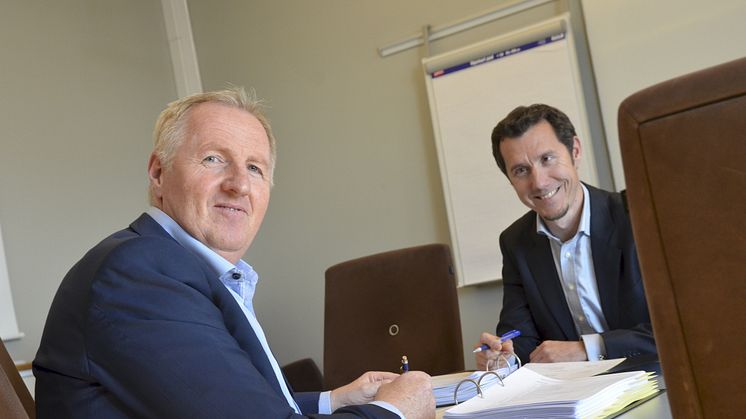 Avdelingsdirektør Torgeir Strypet hos Difi (t.v.) signerer avtalen hos Thomas Mathisen i Posten Norge.