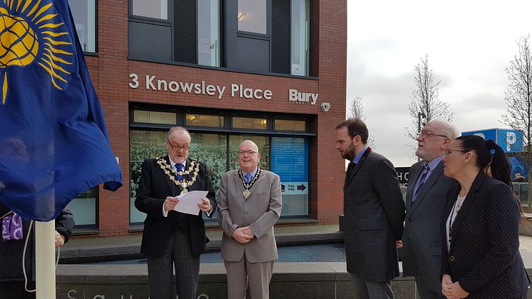 Civic leaders raise the Commonwealth Flag outside Knowsley Place