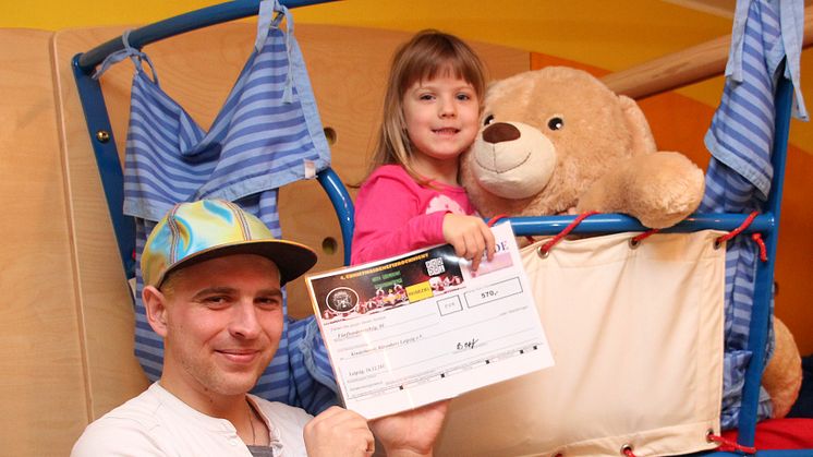 John Rahmlow mit seiner Tochter präsentieren stolz den Spendenscheck im Kinderhospiz Bärenherz