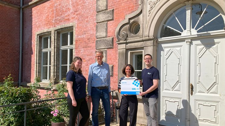 Johanna Franz, Matthias Wind und Christoph Moldenhauer von HanseGas (1,2 und 4 v.l.) übergeben Susanne Crome (3. von links) vom Hospiz Schloss Bernstorf die Spende.