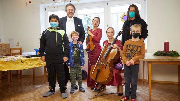 zu lassen.  v.l. Chefidirigent und Intendant der Bayerischen Philharmonie Mark Mast, Musikerinnen Julia Linden (Violine) und Anna Rehker (Violoncello) mit Mara Bertling (DEIN MÜNCHEN) und kleinen Konzertgästen.