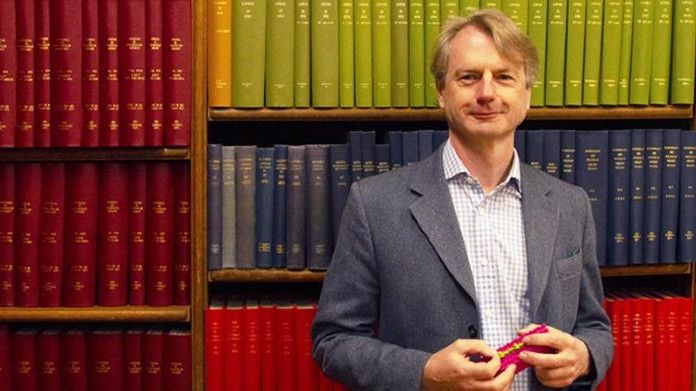 Paul Dupree holding a model of cellulose and xylan, the two most abundant polysaccharides in wood. (Photo: Rhys Grant)