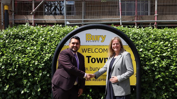 Cllr Tamoor Tariq and Cllr Lucy Smith shaking hands in front of Bury Town Hall