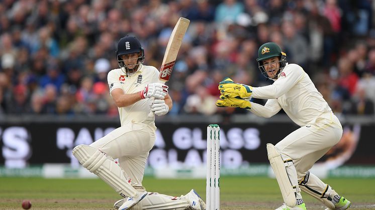England Test captain Joe Root (left) plays a sweep shot as Australian Test captain Tim Paine looks on (Getty Images)