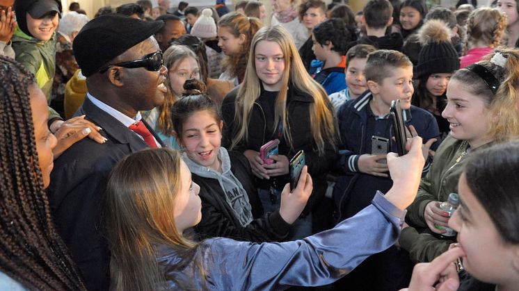 På denna bild från ett av förra årets skolbesök tar skolbarn selfies med en av 2017 års barnrättshjältar, Manuel Rodrigues.