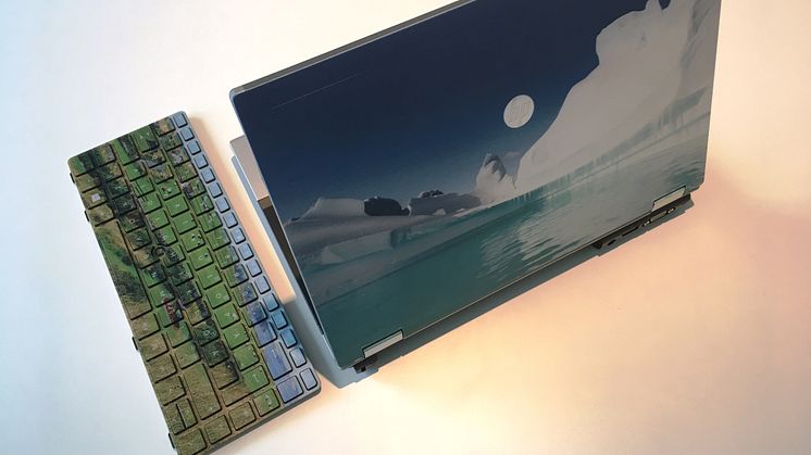 Dator med egen design. Tangentbord med böljande landskap från Skottland och datorlock med naturskönt motiv från Antarktis. 
