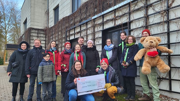 Der Gewandhauschor präsentiert stolz den Spendenscheck vor dem Kinderhospiz Bärenherz.