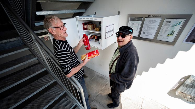 Grannarna Ingemar Olsson och Jan Jönsson visar exempel på varor som donerats till Grannskåpet.  Foto: Björn Lilja