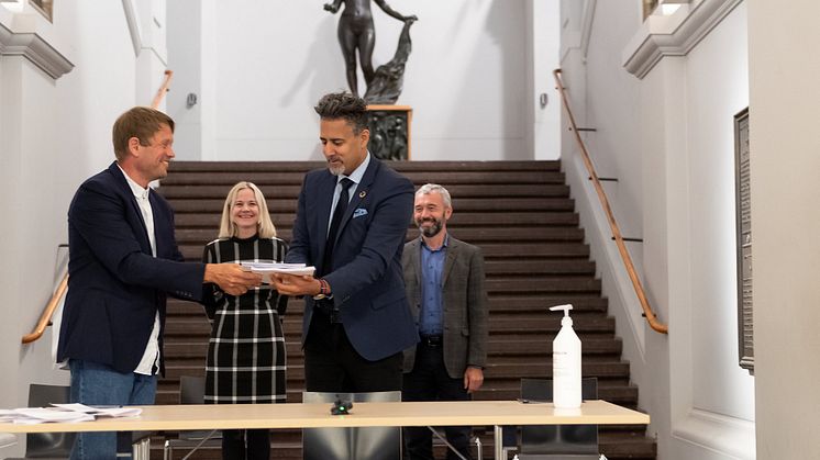 Prosjektleder Martin Eia-Revheim overleverer mulighetsstudien for Nasjonalgalleriet til kulturminister Abid Q. Raja. I bakgrunnen Nasjonalmuseets direktør Karin Hindsbo og Sparebankstiftelsen DNBs direktør André Støylen.