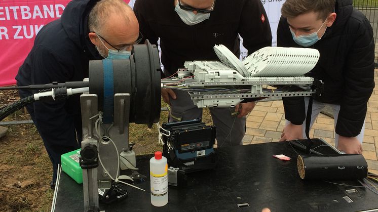 Foto: Dr. Benfer - Landrat Daniel Kurth und Schüler Ian schauen einem Telekom-Techniker beim Spleißen von Glasfaser vor der Oberschule Schwanebeck zu