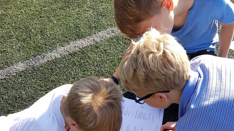 Elever ved Slåtten skole sjekker granulat på fotballbanen (Foto: Lillian Helleseth Furnes)