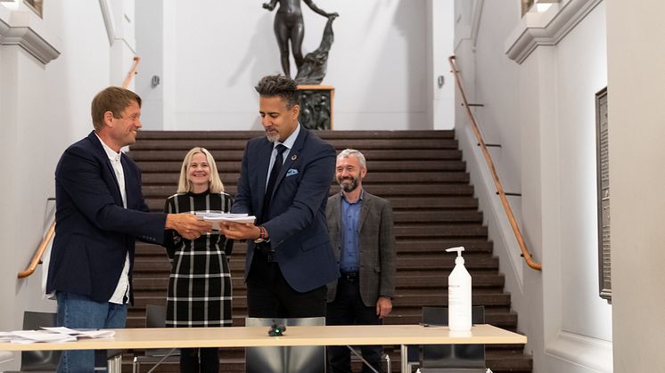 Prosjektleder Martin Eia-Revheim overleverer mulighetsstudien for Nasjonalgalleriet til kulturminister Abid Q. Raja. I bakgrunnen Nasjonalmuseets direktør Karin Hindsbo og Sparebankstiftelsen DNBs direktør André Støylen. (Foto: Frode Larsen)