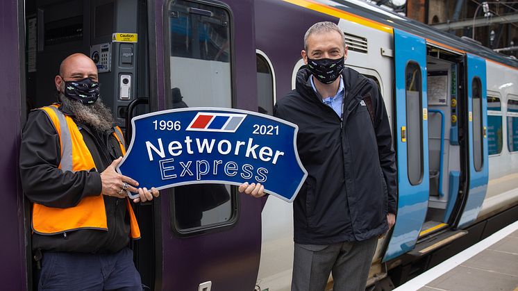 Driver Paul French (left) and Route Operations Assurance Manager Steve Castle proudly hold the headboard ahead of the last Class 365 out of King's Cross