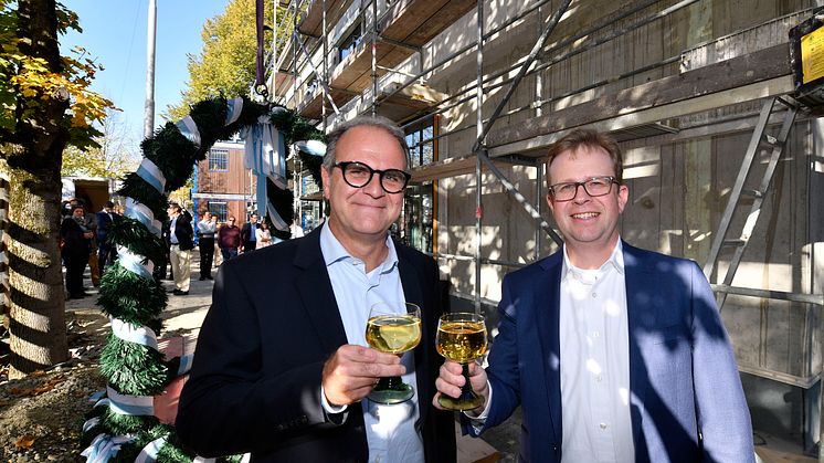 Dr. Bernd Hochberger (re.), Vorstandsmitglied der Stadtsparkasse München, stoßt zusammen mit dem Leiter des Immobilienmanagements, Michael Rubenbauer, auf das Richtfest des Neubaus in der Belgradstraße 162 an.