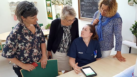 ​Susanne Edfors, undersköterska på Enebergs äldreboende, demonstrerar appen för Eva Nagy, Ulla Frisk och Christina Engius från Arbetsmiljölyftet.