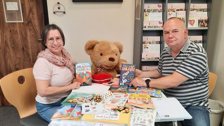 Kerstin Stadler vom Kinderhospiz und Carsten Pergande präsentieren die Sachspenden der Buchhandlung Ludwig