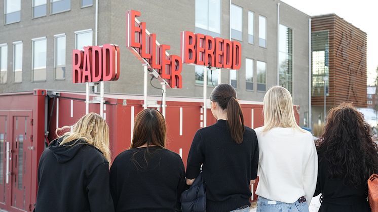 Utställningen Rädd eller beredd med elever bredvid, utanför en skola i Västerås. Foto: Calle Käck