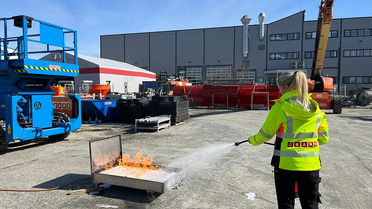 Øvelse brannslukking.jpg: Øvelse gjør mester. Her trener Cramo-medarbeider på å slokke en brann dersom ulykken skulle være ute. (foto:Cramo)