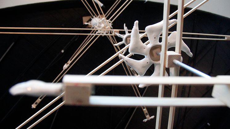Bild: detalj av skulptur med roterande hjul på metallstavar 
