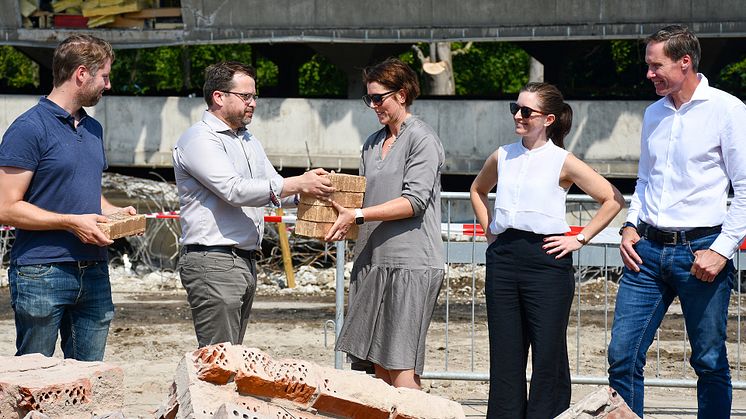 Tony Johansson, LKFs styrelseordförande, lämnar över en av stenarna till Anneli Olkvist, byggprojektledare LKF, som kommer att återbruka teglet i det kommande projetet Levla i Norra Fäladen. Foto: Johan Alsén, LKF. 