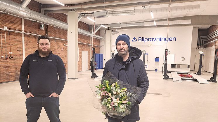 Bilprovningen firar sin nyöppnade station i Jakobsberg med att ge blommor till den första kunden. Foto: Bilprovningen
