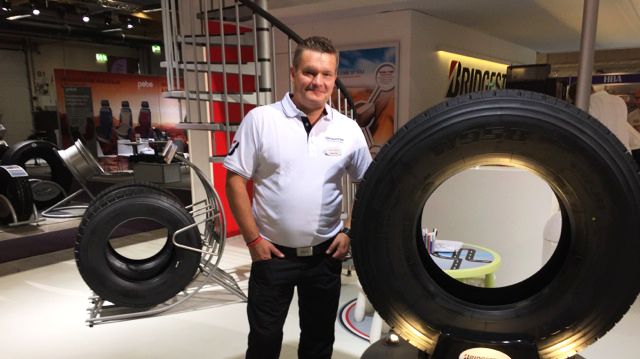 Thomas Nilsson bredvid nya däcken Bridgestone W958 för 9- och 10-tons styraxel i 385/65 R 22,5.