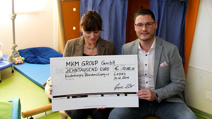 Marco Lotz übergibt den Spendenscheck bei einem Besuch des Kinderhospizes Bärenherz an Mona Meister