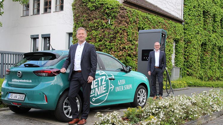 Zwei für Westfalen Weser wichtige Themen vereint: Jürgen Noch (v.) und Andreas Speith mit einem der beiden Elektroautos nur für Azubis.