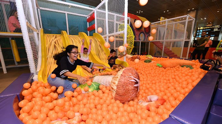 Kids having a great time sliding down a 'noodle' slide into a Mala hotpot ball pit  at the Flavours of China playground