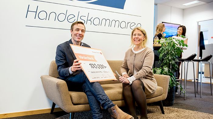 Oskar Axelsson, regionchef på Handelskammaren Mälardalen, tar emot checken på 100 000 kr från bankens VD Cecilia Jeffner.