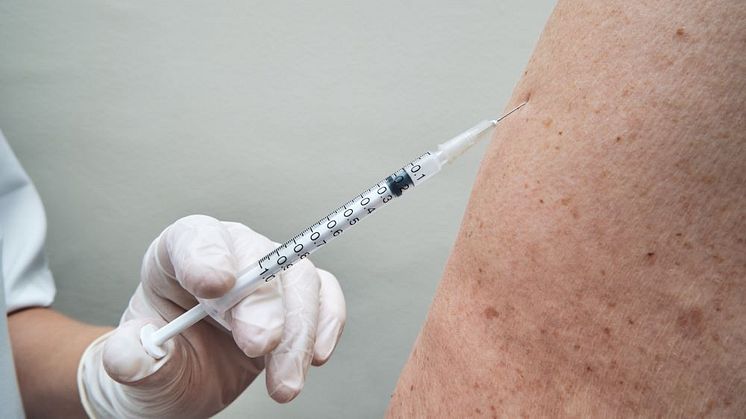 Äldre person får vaccin av vårdpersonal 