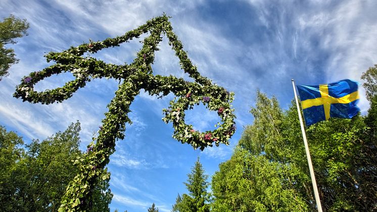 Bild på majstång och en svensk flagga en sommardag.