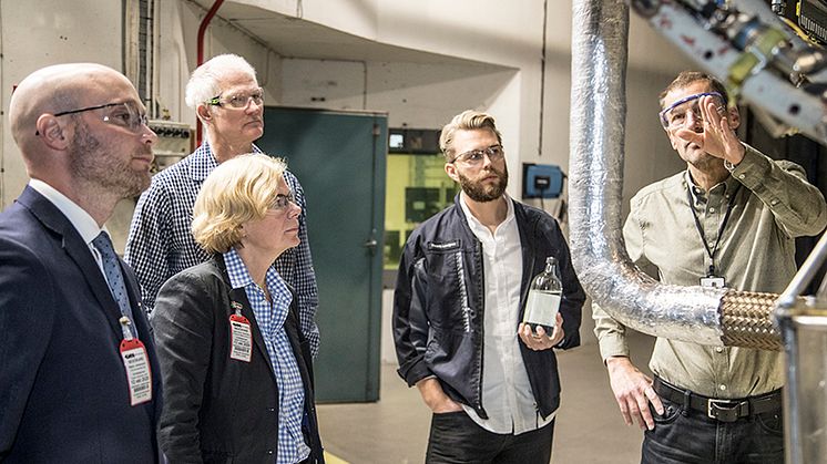 Håkan Schmidt, GKN visar RM12-motorn för fr v Håkan Johansson, Försvarsmaktens Hållbarhetssektion, Ingela Bolin Holmberg, FMV, Torbjörn Hillerström, och Fredrik Lundgren med ett biobränsleprov i handen, båda GKN. Foto: Jukka Lamminluoto.