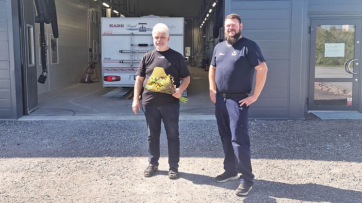 Pär Engström, vars verksamhet är granne med stationen, var vår första kund och välkomnades med blommor av stationschef Daniel Sturesson. Foto: Bilprovningen