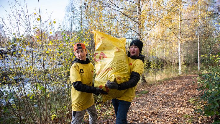 Två deltagare med en av många välfyllda säckar med skräp, fylld under Klara, färdiga, städa! 