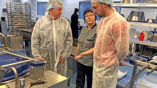 Lars Janke (til venstre), Gitte Larsen og Jakob L. Nielsen snakker om de opnåede strømbesparelser i storkøkkenet. 