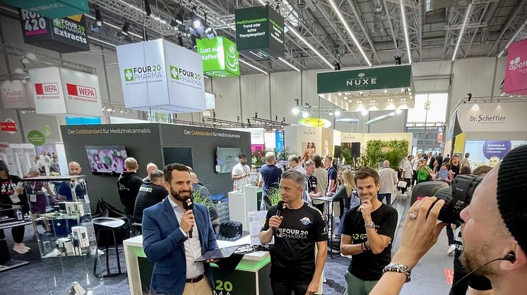 Thomas Schatton (schwarzes Trikot, Mikro) und Torsten Greif (schwarzes Shirt) beim Interview mit dem Messe-TV der expopharm.