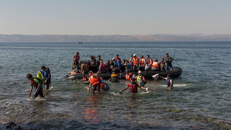 Flyktingar anländer strand
