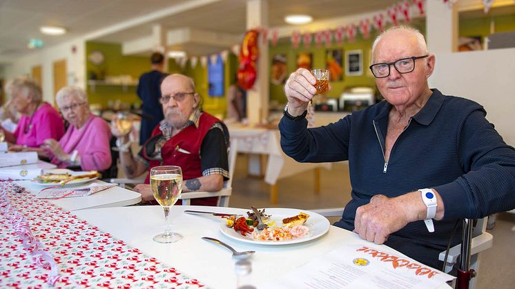 Stig Andersson höjer snapsen för att utbringa en skål tillsammans med vännerna på boendet.