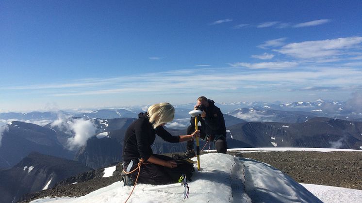 Forskaren Gunhild Ninis Rosqvist mäter höjden på sydtoppen av Kebnekaise som i juli år har minskat med fyra meter på grund av den rekordvarma sommaren.  Foto: Carl Lundberg