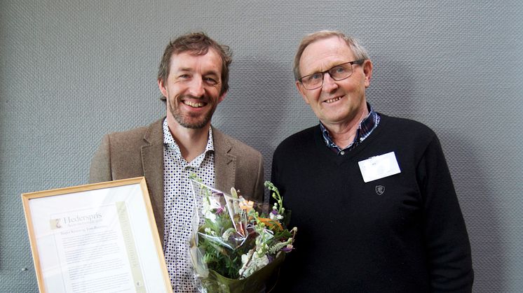 Jasper Kroon fra Solhatt mottok diplom og blomster fra styreleder Jostein Trøite, da Solhattgartnerne ble hedret med prisen Årets Meitemark 2018. Foto: Økologisk Norge