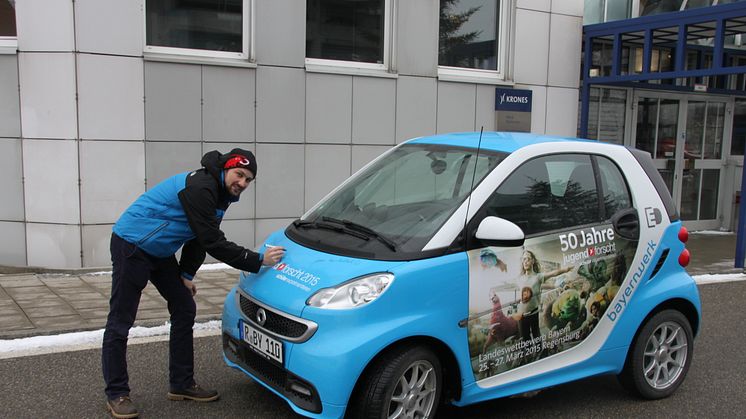 Foto: Mit dem „50 Jahre Jugend forscht E-Smart“ trifft das Patenunternehmen Bayernwerk ehemalige bayerische Preisträger, hier Lukas Kerner, und lässt diese das Elektroauto signieren.