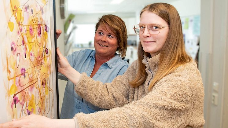 Utställare Emma Karlsson (t.h) och psykiatrihandledare Helen Rasmusson är igång med att färdigställa konstutställningen inför vernissagen