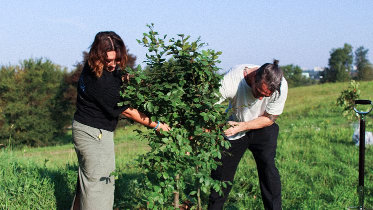 Sustainability Manager at NorthSide, Martin Thim, plants a symbolic tree on the festival's ground in Eskelunden, Aarhus, alongside Marketing Intern Signe Møller