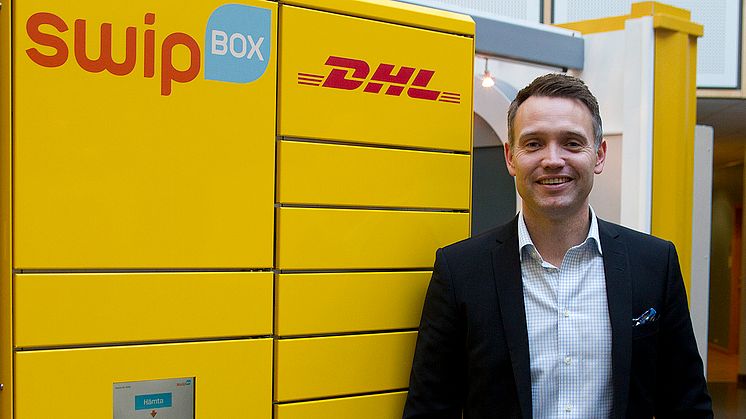 Ted Söderholm, vd DHL Express Sverige, framför en DHL SwipBox-automat.