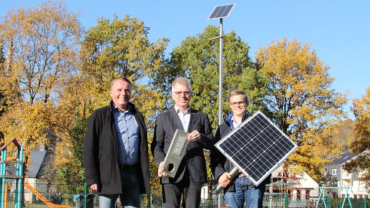 Andreas Ruprecht, Bereichsleiter Beleuchtung WWN, Bürgermeister Hans Jürgen Wessels und Florian Wiesing, Projektleiter Straßenbeleuchtung WWN mit den Hauptkomponenten der Solarleuchte.